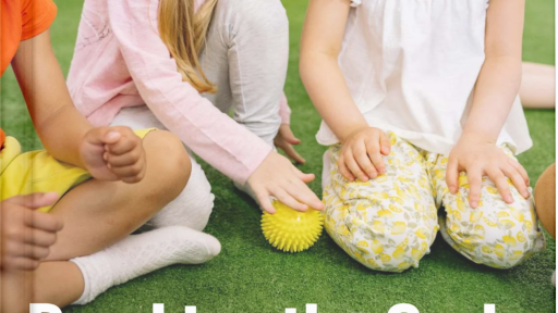 Three young girls sit on a green carpet, playing together with a yellow spiky ball and appearing engaged and friendly. The book cover reads "Breaking the Cycle: Ending Bullying in Schools"—an eBook available to Premium Members.