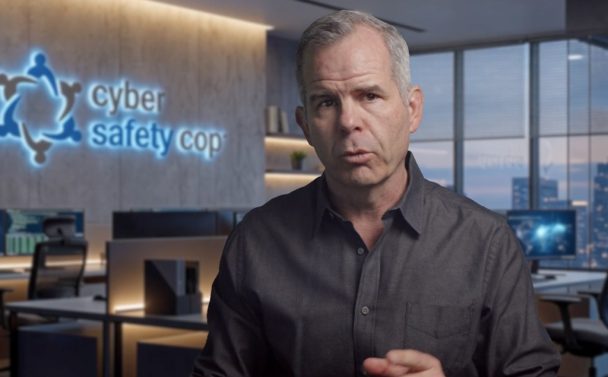 A man with gray hair wearing a dark shirt stands in a modern office. Behind him, a glowing "cyber safety cop" sign and several computer workstations set the scene for Episode 01 on AI Chatbots.